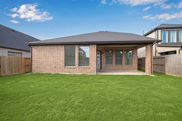 rear view of house with a lawn and a patio