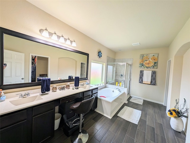 bathroom featuring shower with separate bathtub and vanity