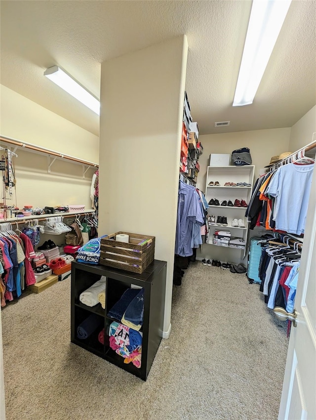 walk in closet with carpet flooring