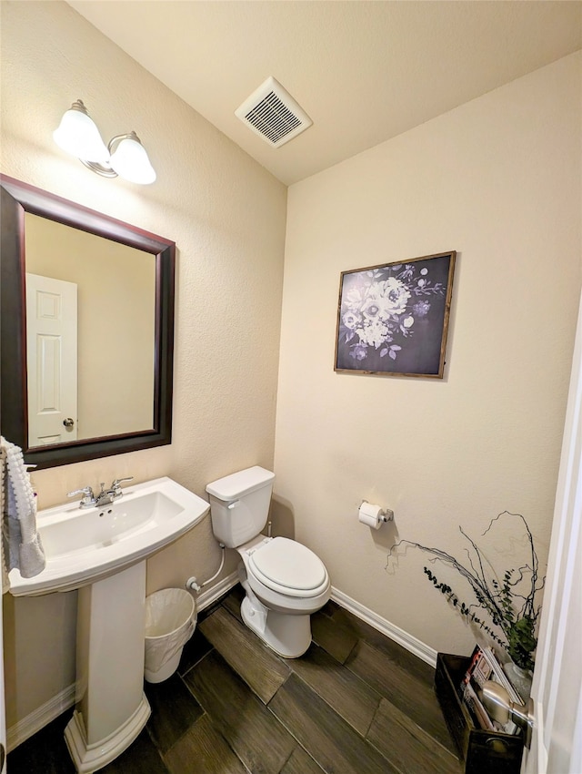 bathroom with toilet and hardwood / wood-style floors