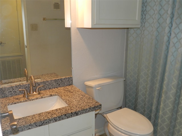 bathroom featuring toilet and vanity