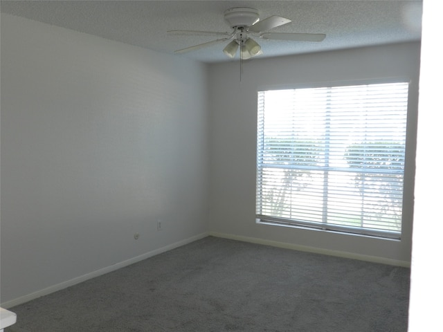 unfurnished room featuring a textured ceiling, dark colored carpet, and ceiling fan