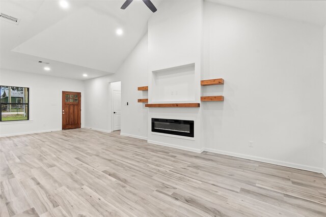 unfurnished living room featuring ceiling fan, light wood-type flooring, and high vaulted ceiling