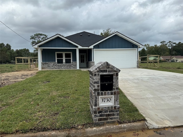 view of front of property featuring a garage, a front yard, and a porch