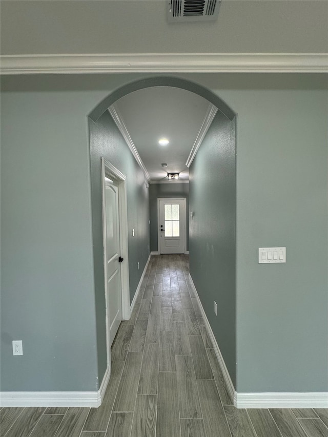 hallway featuring wood-type flooring and crown molding