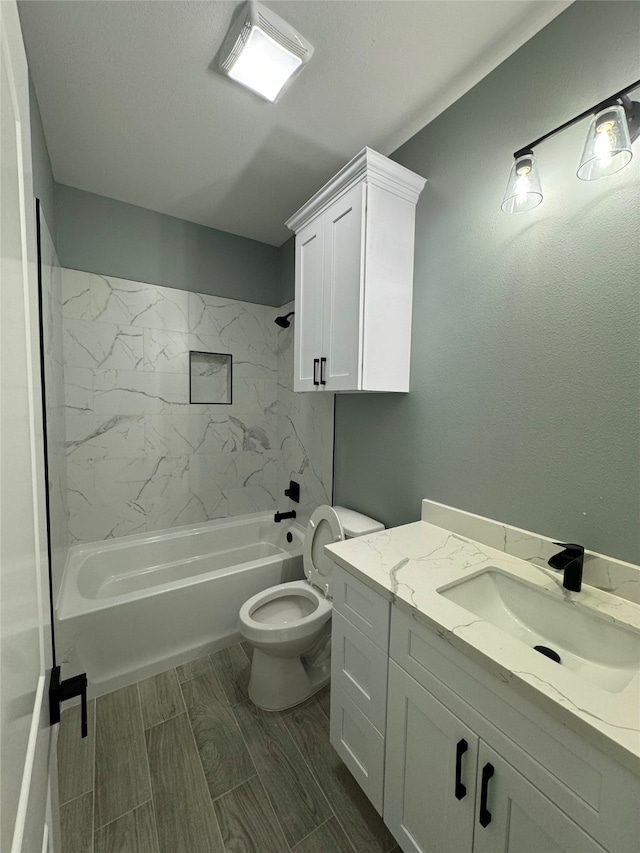 full bathroom with toilet, vanity, and tiled shower / bath