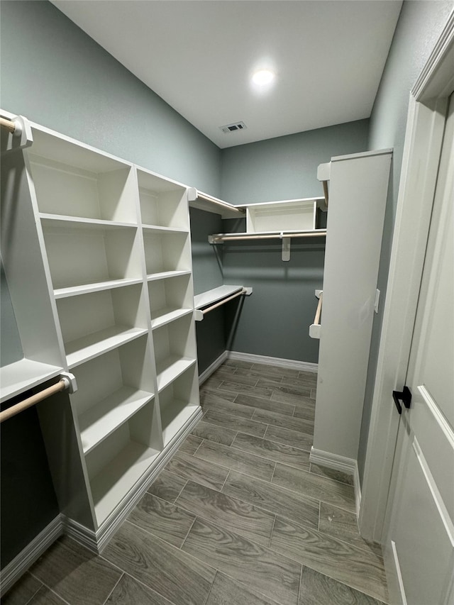 walk in closet with dark hardwood / wood-style flooring