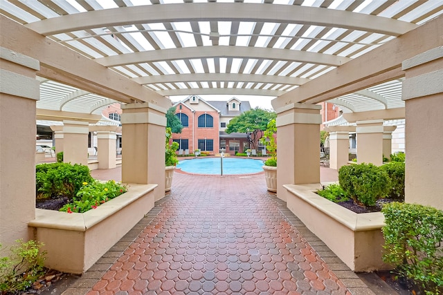 view of patio featuring a pergola and a community pool