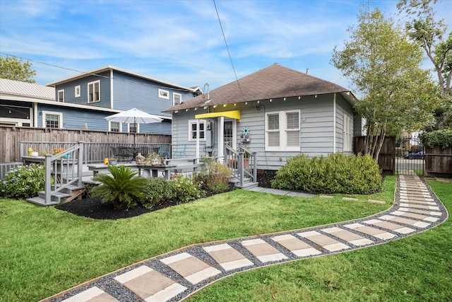 view of front of property with a front yard, a wooden deck, and cooling unit