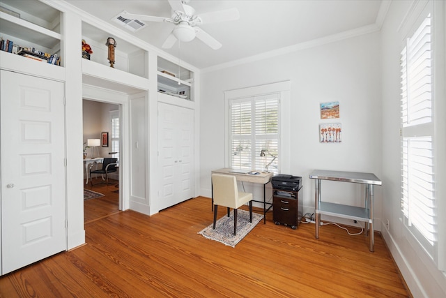 unfurnished office with hardwood / wood-style floors, ceiling fan, built in shelves, and ornamental molding