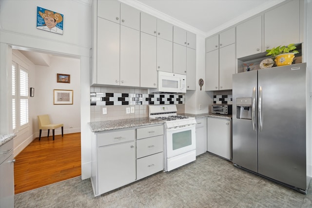 kitchen featuring white cabinetry, tasteful backsplash, white appliances, and light stone countertops