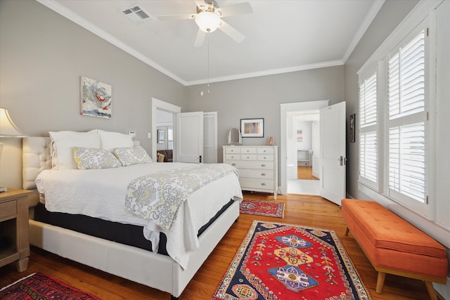 bedroom featuring hardwood / wood-style floors, ceiling fan, and crown molding