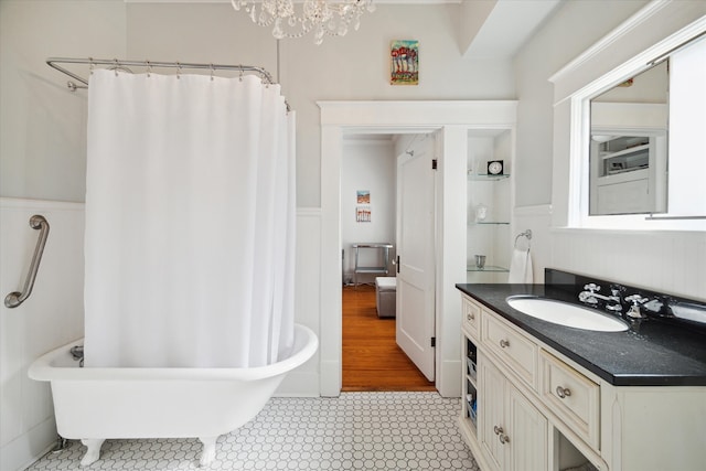 bathroom featuring wood-type flooring, vanity, a chandelier, and a bathtub