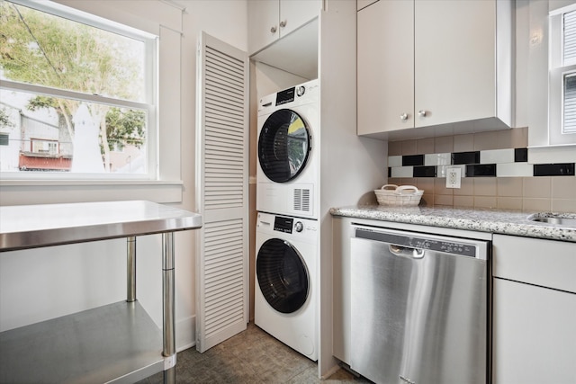 clothes washing area featuring stacked washing maching and dryer