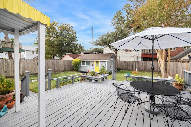 deck with a lawn and a storage shed