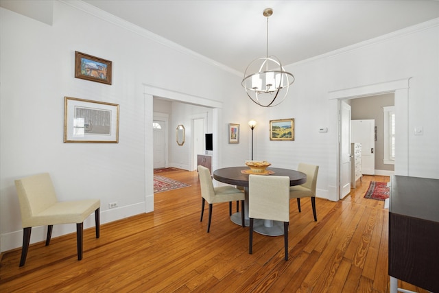 dining space with wood-type flooring, a chandelier, and crown molding