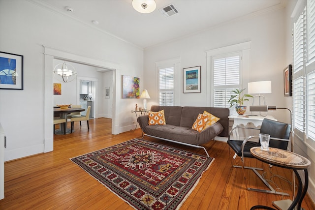 living room featuring hardwood / wood-style flooring, plenty of natural light, and ornamental molding