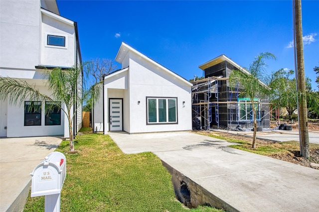 contemporary home with a front lawn and stucco siding