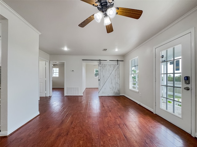 interior space featuring ornamental molding, a barn door, dark hardwood / wood-style floors, and ceiling fan