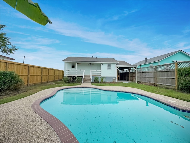 view of swimming pool with a yard and a wooden deck