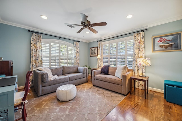 living room featuring plenty of natural light, ornamental molding, and hardwood / wood-style flooring