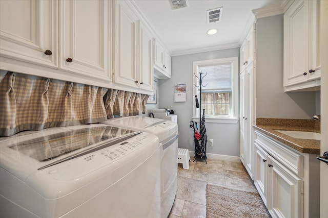 washroom featuring cabinets, separate washer and dryer, sink, and ornamental molding