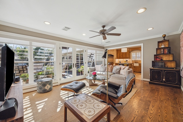 living room featuring french doors, crown molding, plenty of natural light, and dark hardwood / wood-style floors