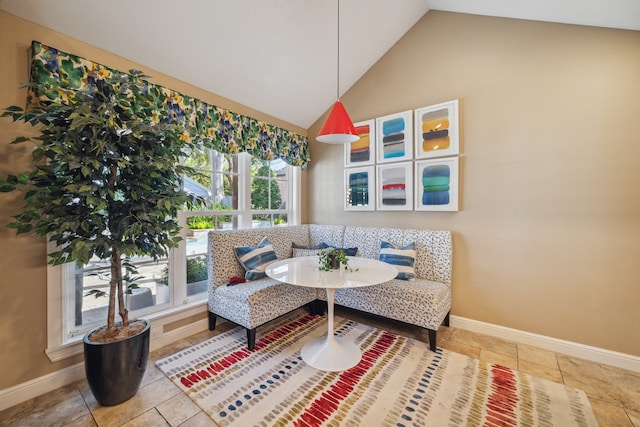 sitting room with breakfast area, tile patterned floors, and lofted ceiling