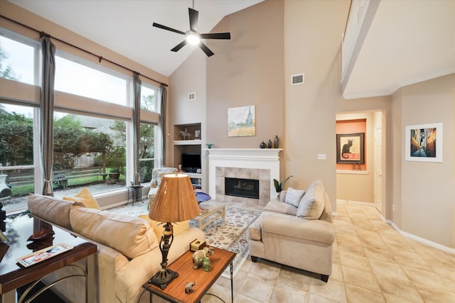 living room featuring high vaulted ceiling, a fireplace, ceiling fan, and light tile patterned floors