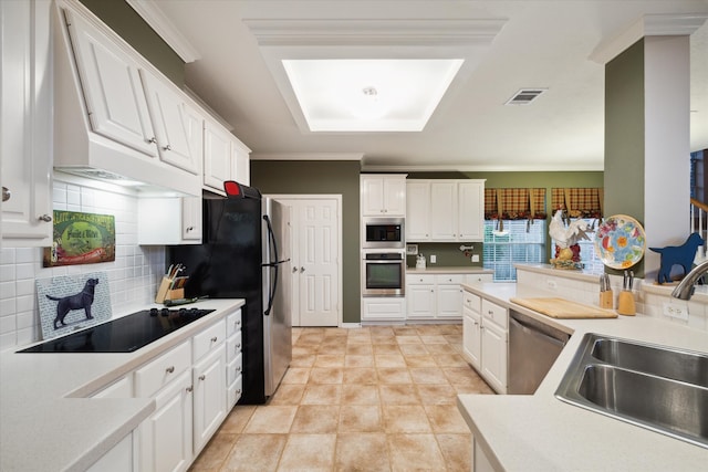 kitchen with stainless steel appliances, white cabinetry, sink, and backsplash