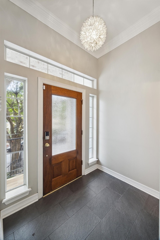 foyer with an inviting chandelier and crown molding