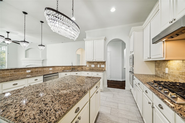 kitchen with appliances with stainless steel finishes, sink, backsplash, and dark stone countertops