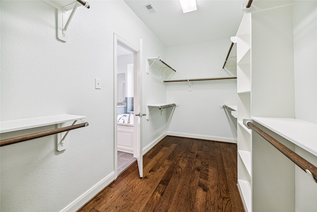 walk in closet with dark hardwood / wood-style flooring