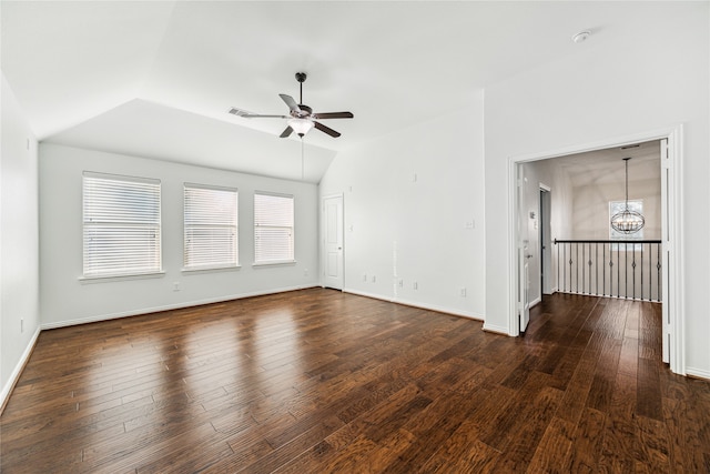 spare room with dark hardwood / wood-style flooring, ceiling fan with notable chandelier, and vaulted ceiling