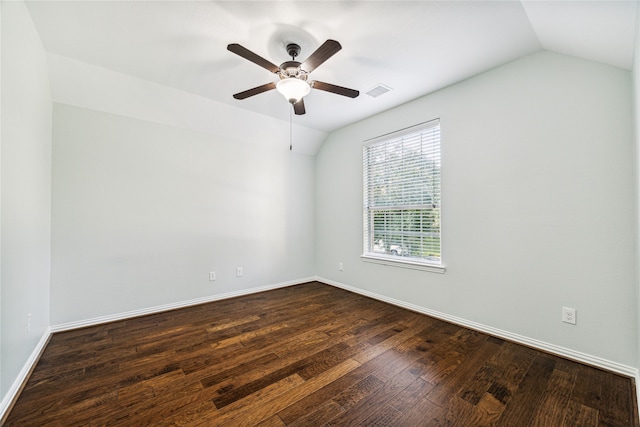 empty room featuring dark hardwood / wood-style floors, vaulted ceiling, and ceiling fan