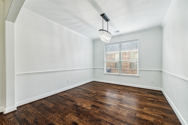 unfurnished room featuring dark hardwood / wood-style flooring, ornamental molding, and an inviting chandelier