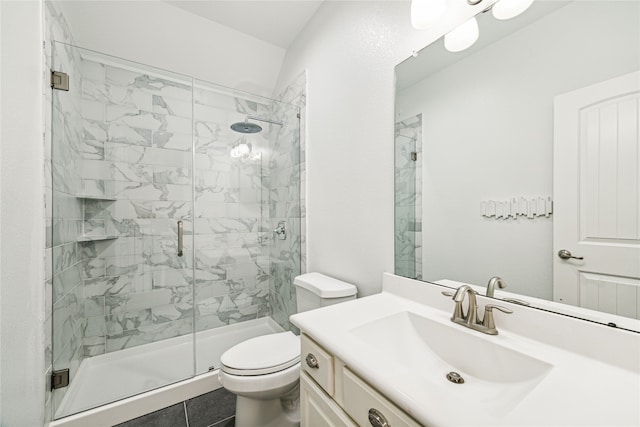 bathroom featuring tile patterned floors, vanity, toilet, and a shower with shower door