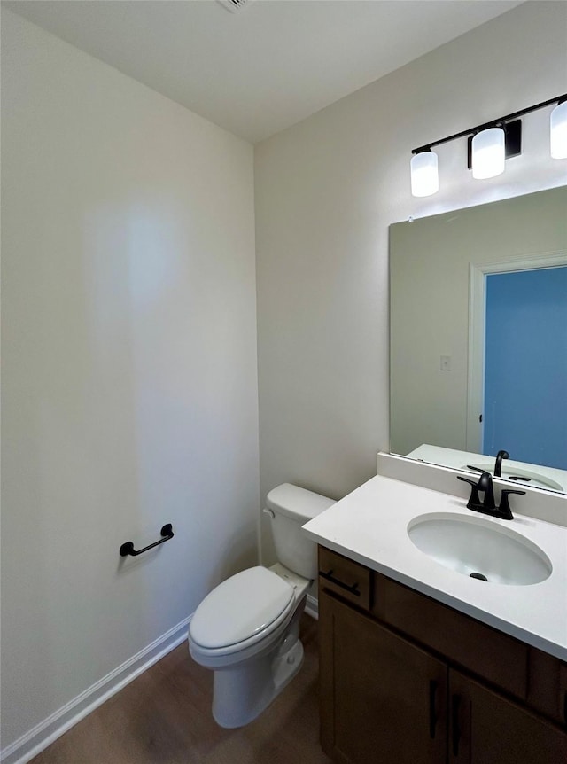 bathroom featuring hardwood / wood-style flooring, vanity, and toilet