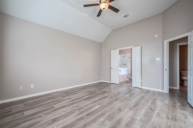 unfurnished bedroom featuring ensuite bathroom, light wood-type flooring, ceiling fan, and high vaulted ceiling