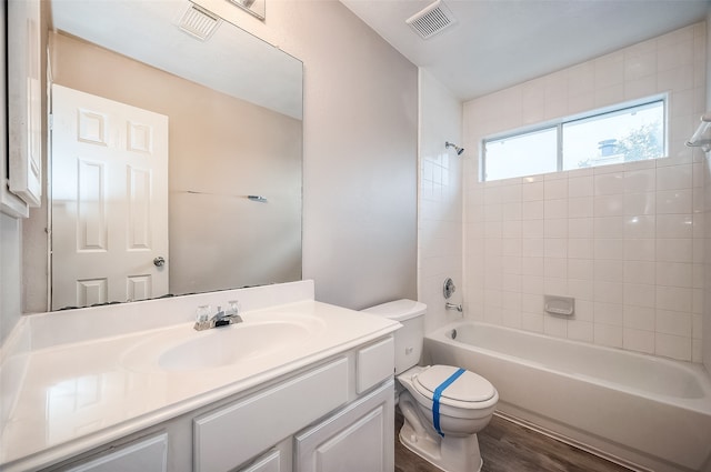 full bathroom with toilet, vanity, tiled shower / bath, and wood-type flooring