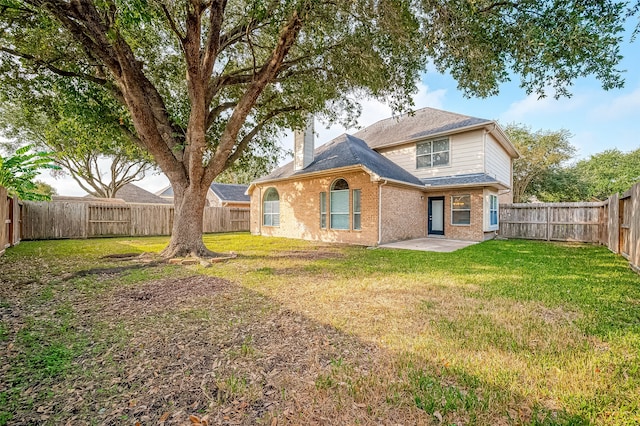 rear view of property with a lawn and a patio