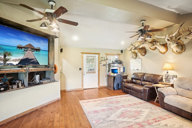 living room with light wood-type flooring, lofted ceiling, and ceiling fan