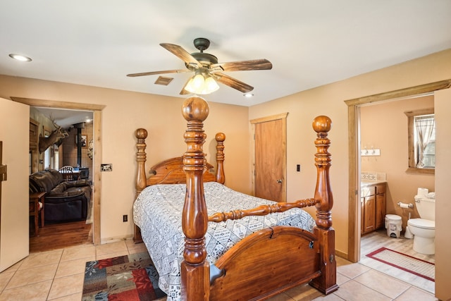 bedroom featuring ensuite bathroom, ceiling fan, and light tile patterned floors