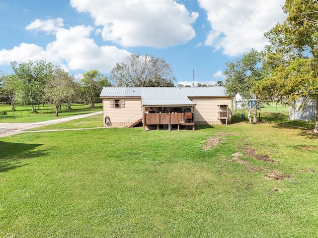 back of property featuring a wooden deck and a yard