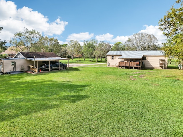 view of yard with a carport and a deck