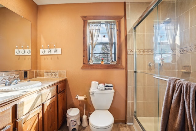 bathroom with an enclosed shower, vanity, hardwood / wood-style flooring, and toilet