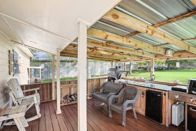 wooden terrace featuring a grill and a lawn