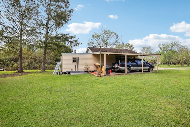 back of house featuring a carport and a lawn