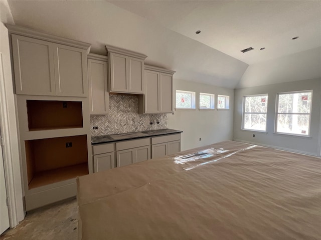 kitchen with gray cabinetry, lofted ceiling, and tasteful backsplash