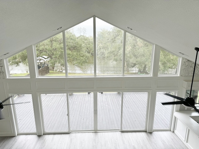 additional living space featuring hardwood / wood-style flooring, a wealth of natural light, ceiling fan, and vaulted ceiling